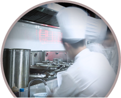 A sous chef in a white hat cooking in a restaurant.
